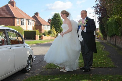 Bride and father entering wedding car