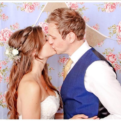 Bride and groom kissing, bride has bridal hair soft and down with twists and flowers