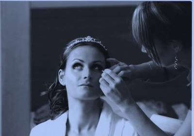 Makeup `Artist Paula Marie applying eye makeup to bride