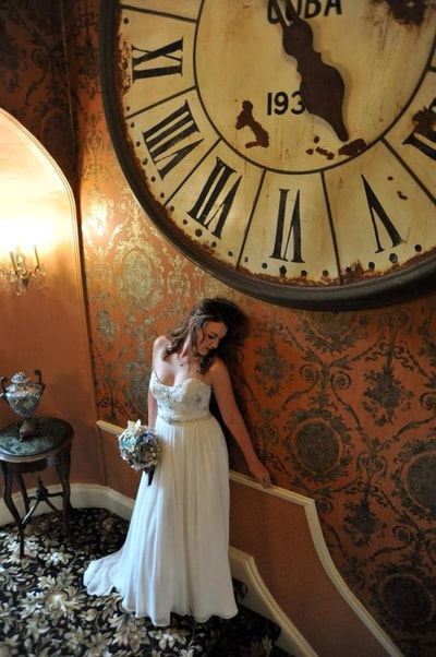 Bride posing near large hotel clock